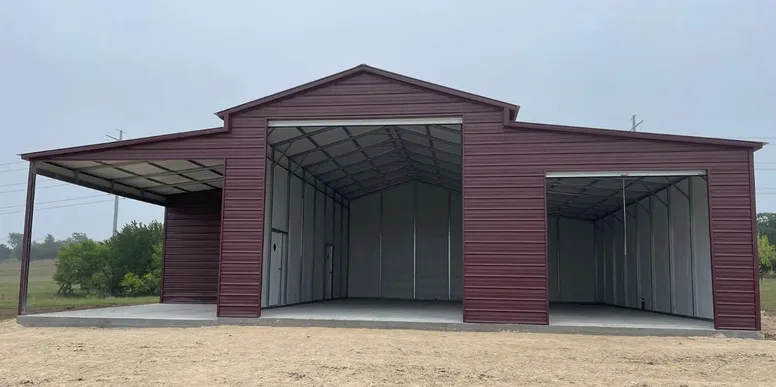Dark red metal workshop with open bays and lean-to